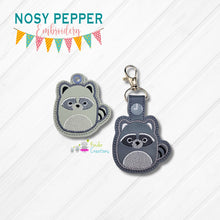 Load image into Gallery viewer, Squishy Raccoon snap tab and eyelet fob machine embroidery file (single and multi files included) DIGITAL DOWNLOAD