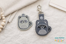 Load image into Gallery viewer, Squishy Raccoon snap tab and eyelet fob machine embroidery file (single and multi files included) DIGITAL DOWNLOAD